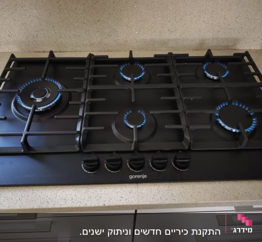כיריים גז שחורות מותקנות בשיש עם להבות גז דולקות